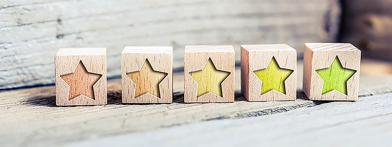 five wooden blocks in line with stars carved into them